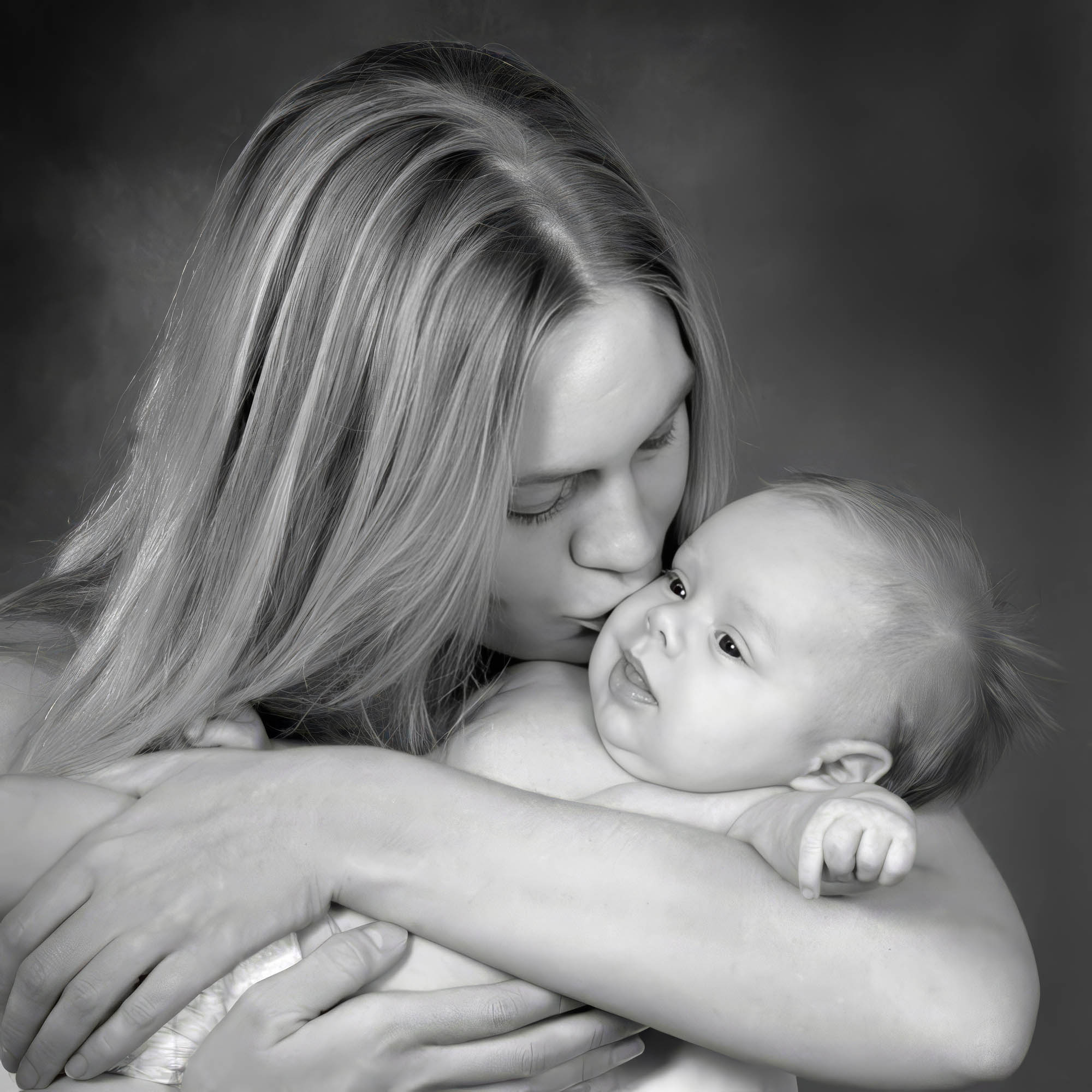 Mor kysser sin baby på kinden i et tæt og kærligt portræt