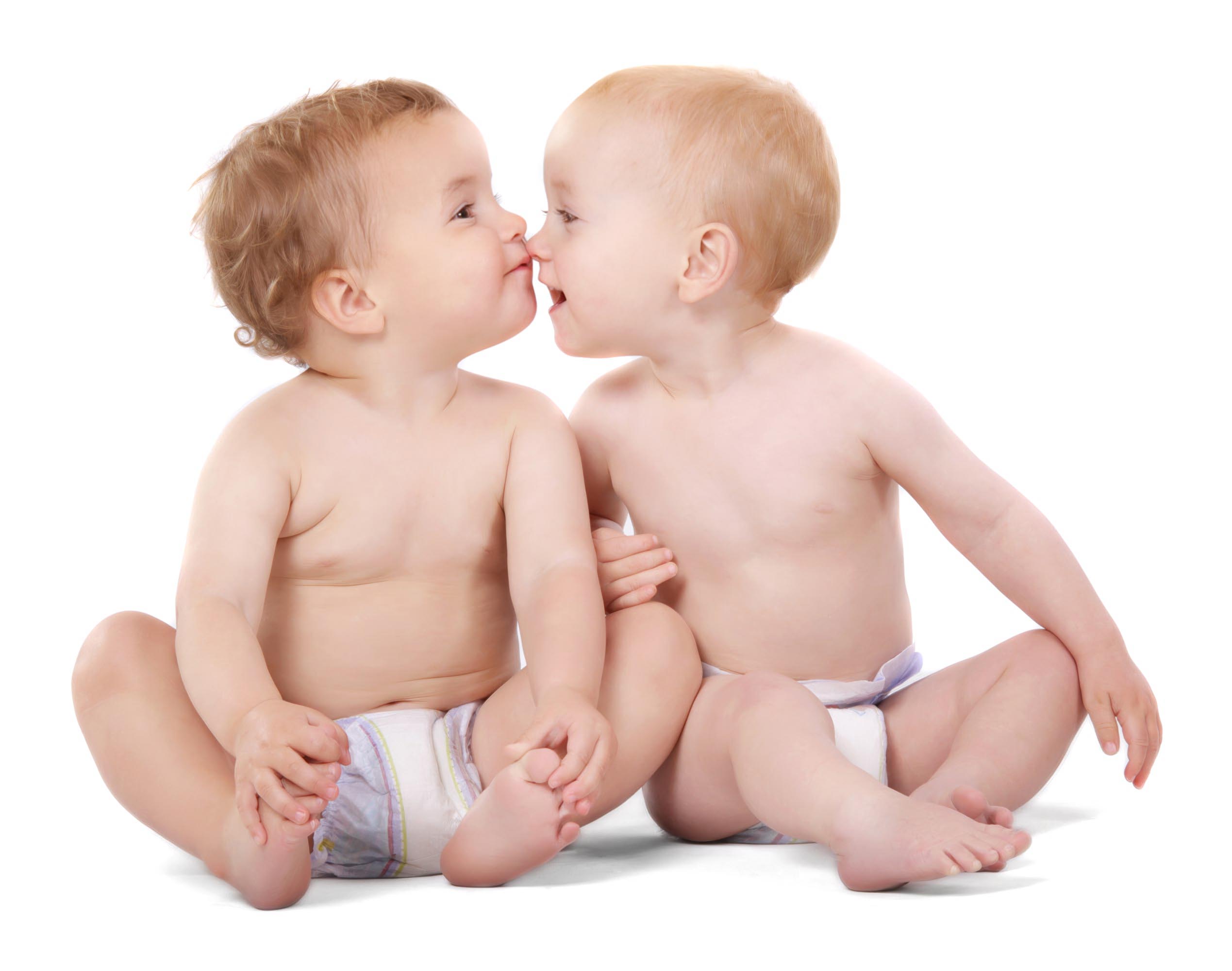 To små børn sidder tæt og rører næser i et lyst studieportræt